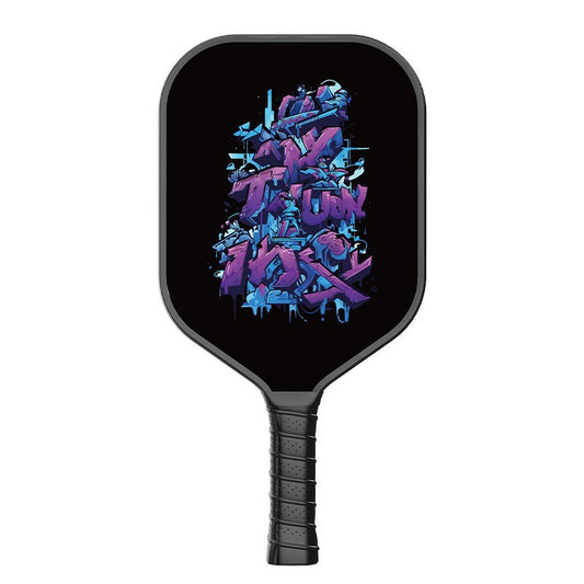 A defensive pickleball paddle featuring purple and blue urban graffiti art style lettering on the face, with a black grip. This is a fiberglass paddle, helping you understand how to hold a pickleball paddle and what is the best pickleball paddle for beginners, ideal for beginners looking where to buy pickleball paddles.