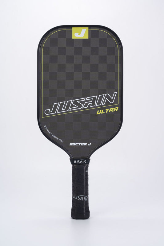Close-up of the black and bright yellow JUSAIN ULTRA pickleball paddle. The paddle face has a checkered texture of 8OZ RAW CARBON/T700 carbon fiber. Suitable for inquiries about what are good pickleball paddles.