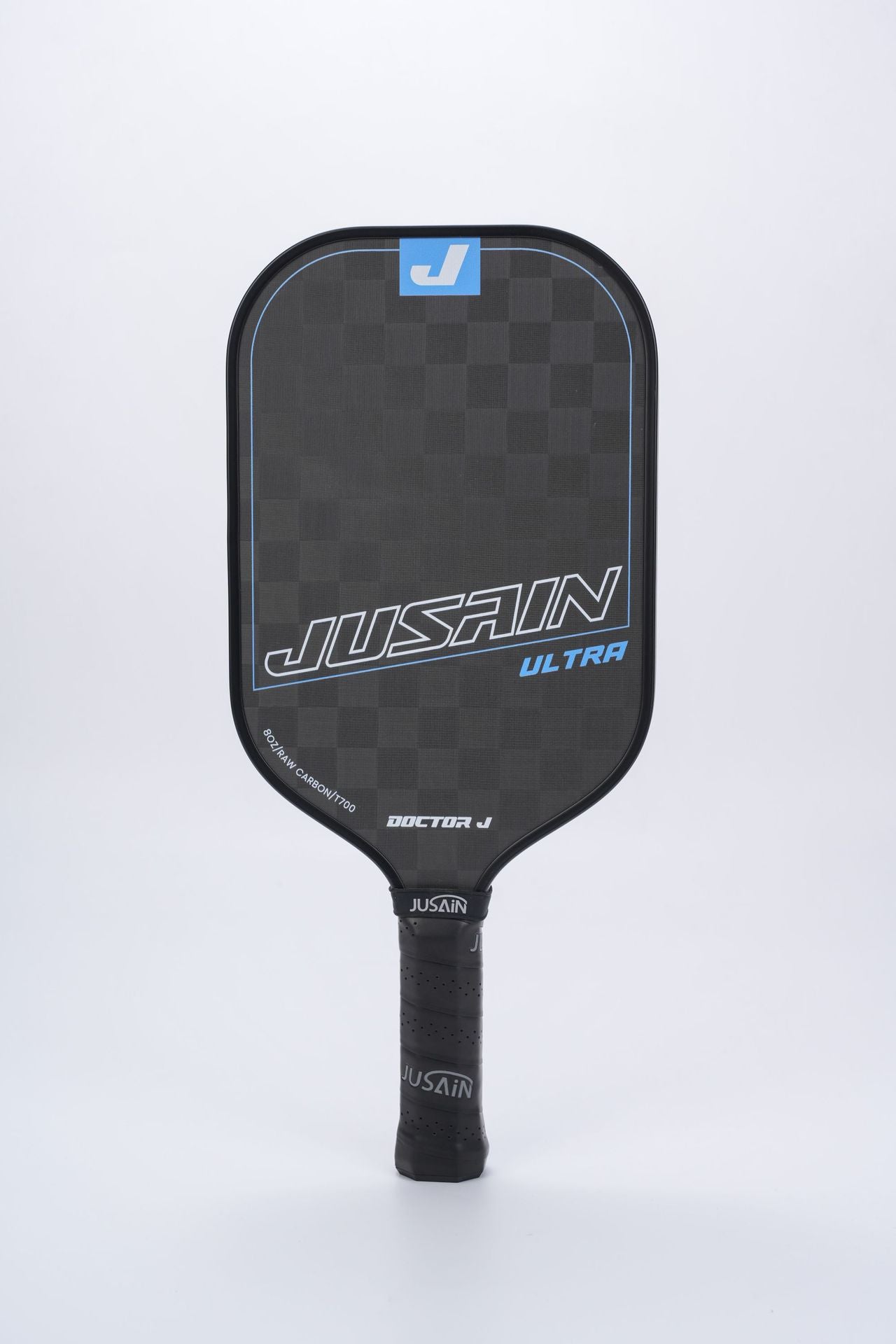 Close-up of the black and blue JUSAIN ULTRA pickleball paddle. The paddle face features a checkered texture of 8OZ RAW CARBON/T700 carbon fiber. This paddle is a quality option for questions about what is the best pickleball paddle for beginners.