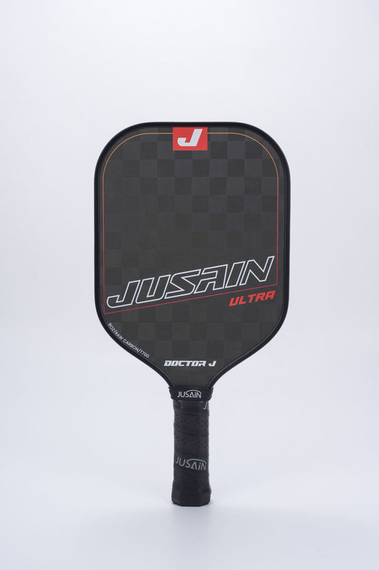 Full front view of the JUSSAIN ULTRA pickleball paddle featuring a black carbon fiber surface with orange-red accent lines and branding. This offers another color choice when looking for where to buy a pickleball paddle, with a professional look and 16mm thickness.
