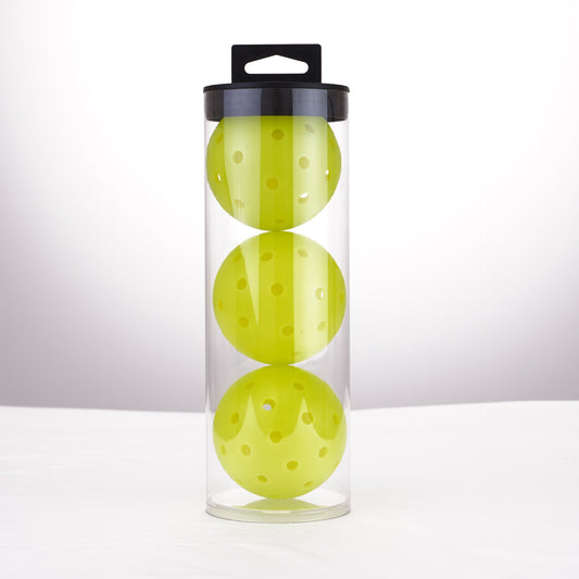 Three lime green 40-hole outdoor pickleballs in a clear tube, ready for tournament play.