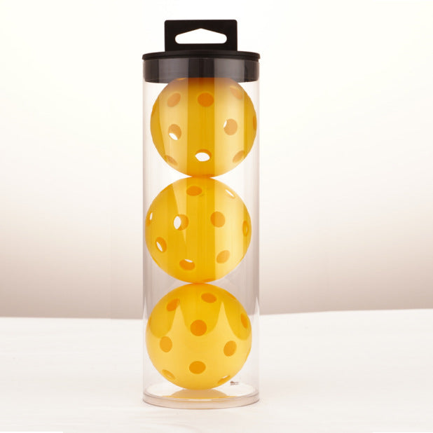 Three yellow 40-hole outdoor pickleballs in a clear tube, showcasing the durable design.
